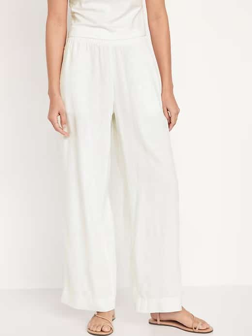 A model wearing breezy, white linen pants that are perfect for any summer outfit.