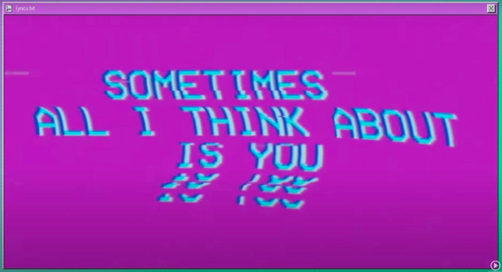 The image is from the lyric video for "Heat Waves," the lyrics "Sometimes all I think about is you" are on the screen with a pink background.