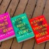 The A Court of Thorns and roses trilogy laid out on a wooden background.