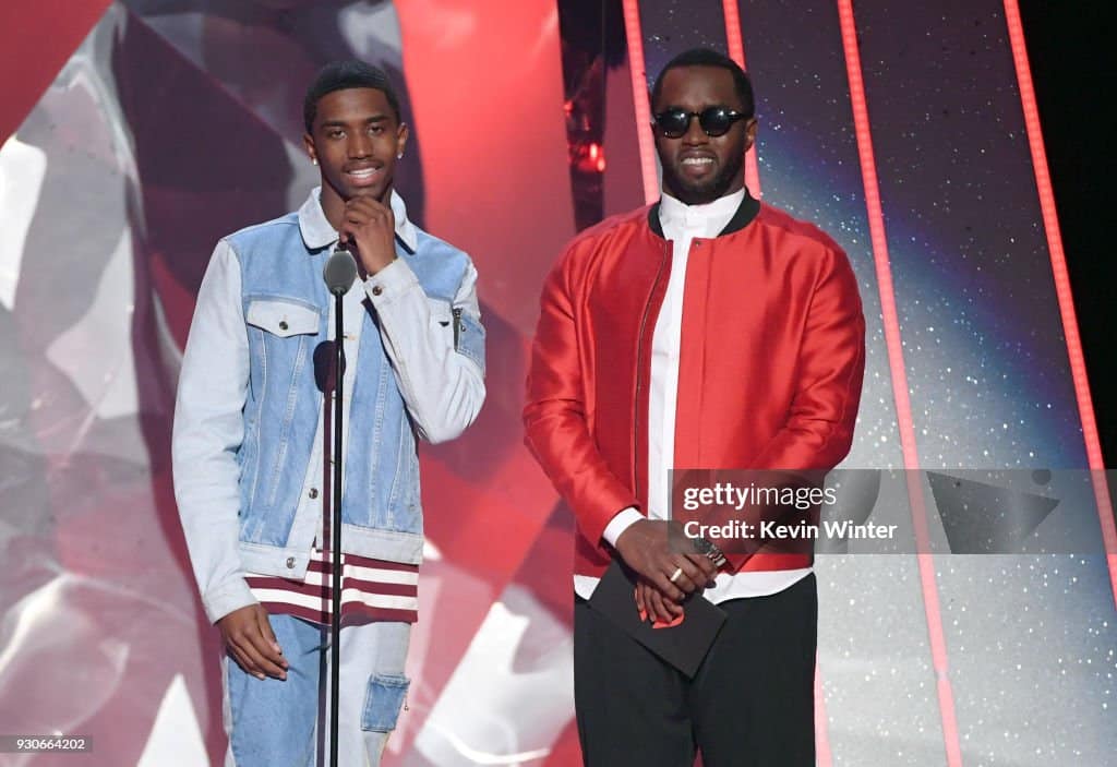 Christian Combs and Sean 'Diddy' Combs speaking onstage at the 2018 iHeartRadio Music Awards in Inglewood, California, on March 11, 2018.