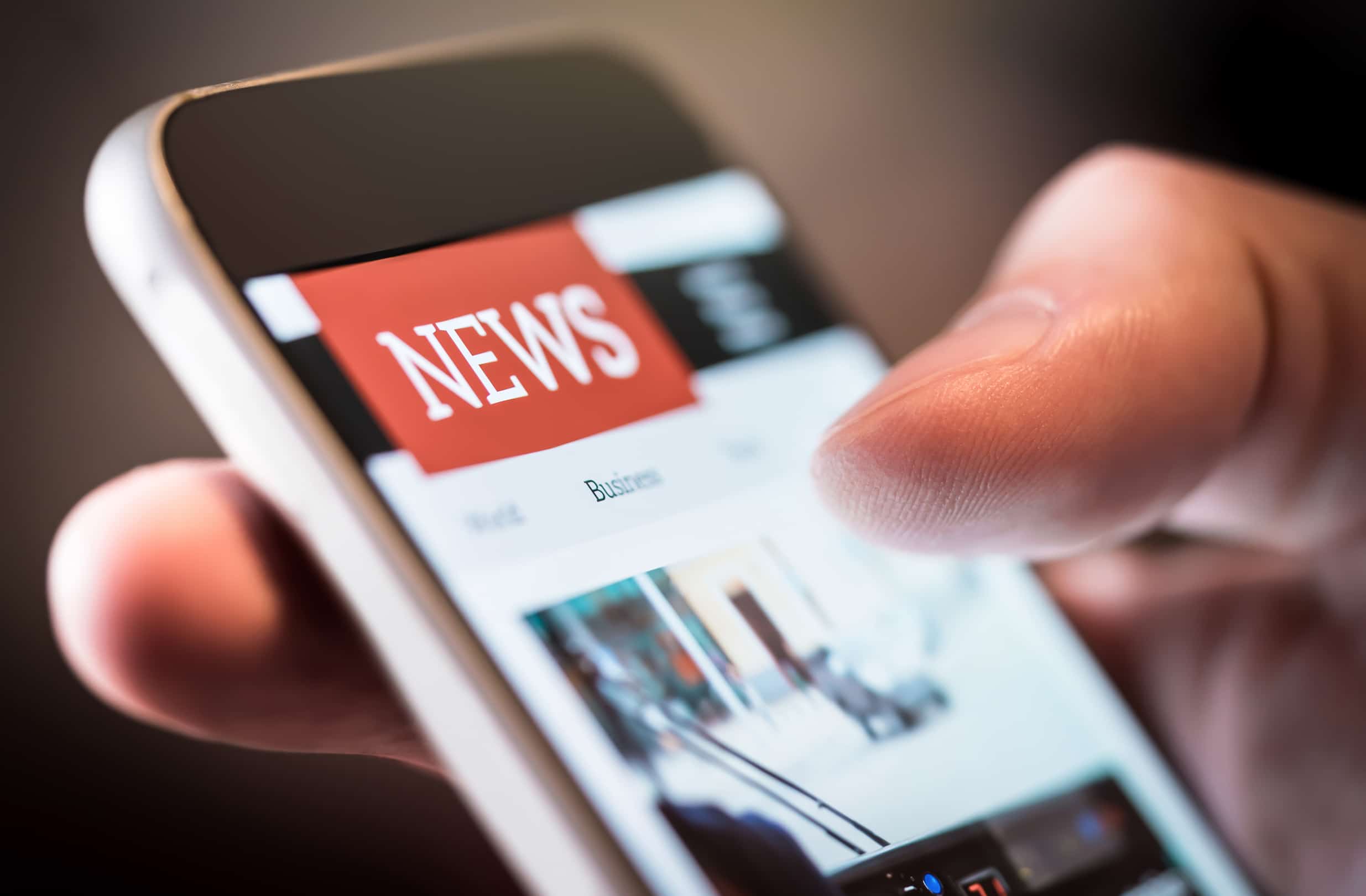 A close up of browsing online news on a mobile phone.