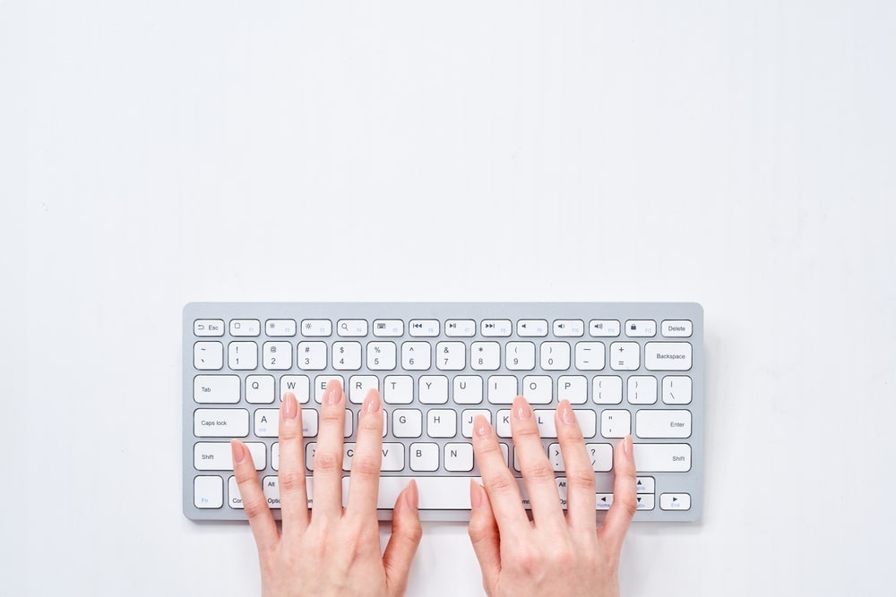 woman's hands typing on keyboard 